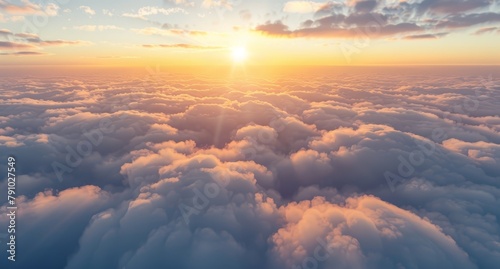   The sun sets behind clouded skies, viewed through an airplane window on a sunlit day photo