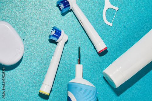 Oral hygiene supplies on a blue color background. Electric toothbrush and oral hygiene products on pastel background.