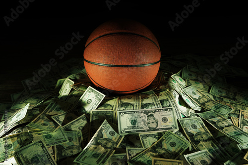 Basketball on a pile of cash -- money and betting in sports concept