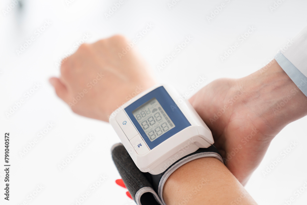 Doctor measuring blood pressure of a young girl using a tonometer Doctor measuring blood pressure of a young girl using a tonometer