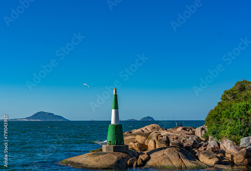 farol sobre as pedras no canal que vem do mar em Florianópolis, Brasil photo