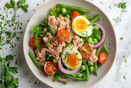 A close-up of a colorful tuna salad with greens, tomatoes, and a perfectly boiled egg for a nutritious meal