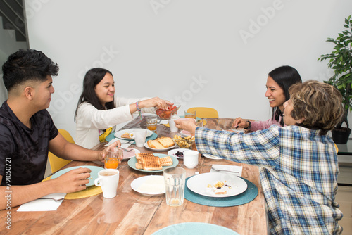 Granddaughter serving food to grandmother during the family breakfast at home