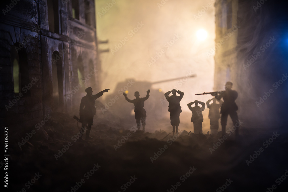 Military silhouettes fighting scene on war fog sky background. A German soldiers raised arms to surrender. Plastic toy soldiers with guns taking prisoner the enemy soldier.