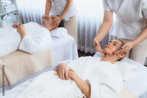 Caucasian couple enjoying relaxing anti-stress head massage and pampering facial beauty skin recreation leisure in dayspa modern light ambient at luxury resort or hotel spa salon. Quiescent © Summit Art Creations