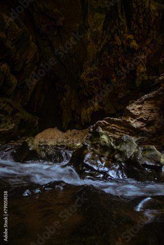 The beautiful views of the stalactite and stalagmite-filled cave in Lam Khlong Ngu National Park, Thailand. At the cave's exit is a small waterfall also.