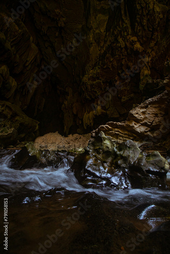 The beautiful views of the stalactite and stalagmite-filled cave in Lam Khlong Ngu National Park, Thailand. At the cave's exit is a small waterfall also.