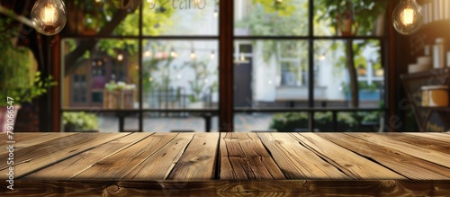 A wooden table with nothing on it and a blurred glass window background for showcasing your products.