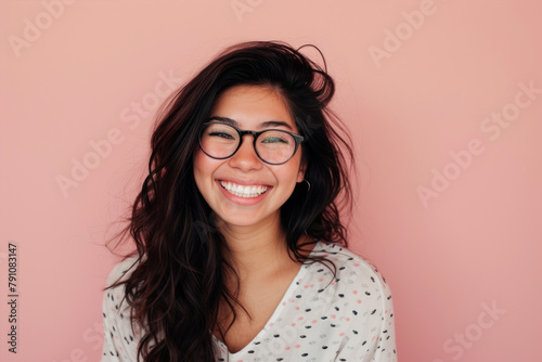 Portrait of a smiling young woman with eyeglasses against pink background