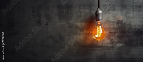 A light bulb suspended by wire on concrete wall photo