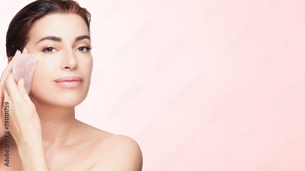 Elegant Woman Using Rose Quartz Gua Sha on Face Skin Elegant Woman Using Rose Quartz Gua Sha on Face Skin