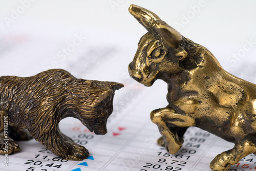 Bronze bull and bear on a financial data