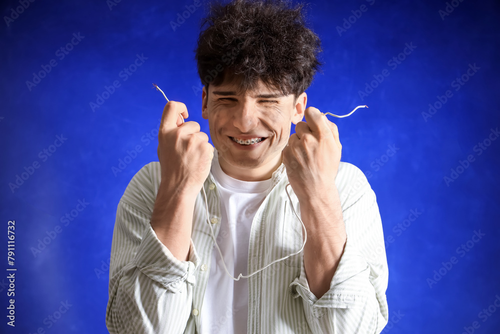 Electrocuted young man with burnt face and wire on dark background, closeup Electrocuted young man with burnt face and wire on dark background, closeup