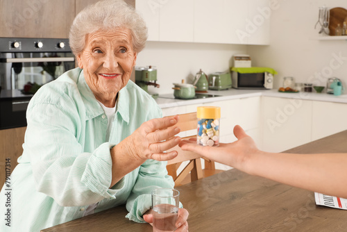 Senior woman taking pill bo...
