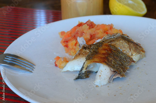 Portion of fried gilthead sea bream with potato, carrot and tomato stoemp and freshly ground white pepper. Selective focus