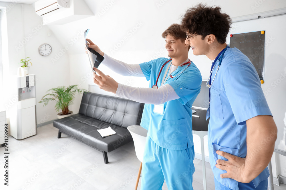 Fototapeta premium Male medical interns examining x-ray scan in clinic