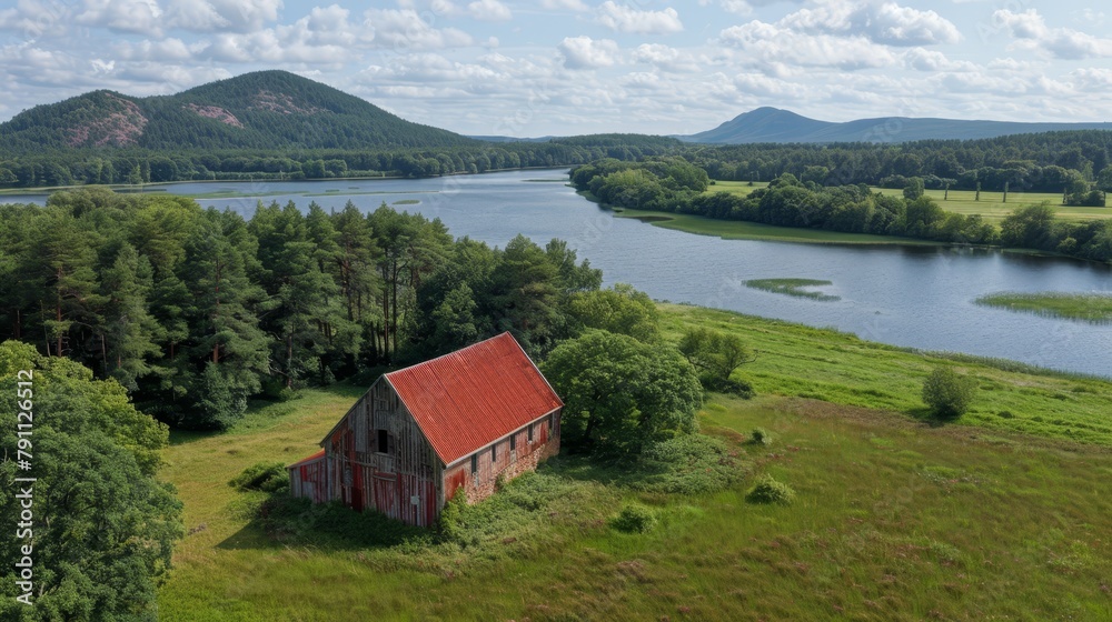   A bird's-eye perspective of a quaint house nestled in a field, encircled by a lake, and framed by mountains