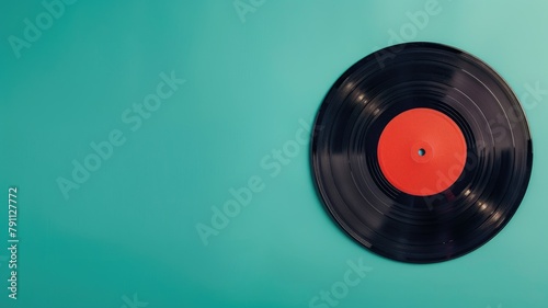 Black vinyl record on teal background  top view