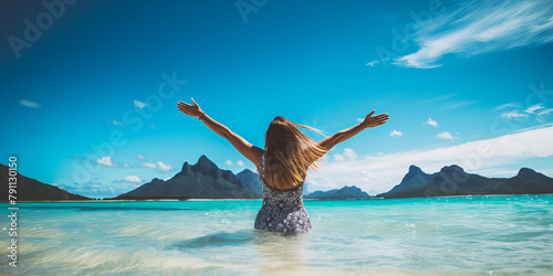 A back view of the beautiful young brunette happy woman in the sea, sun and vaccation. photo