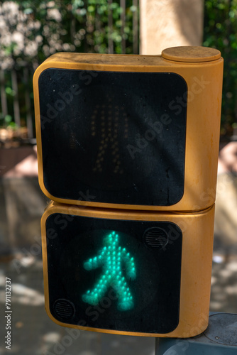 green light with symbol of man walking at a traffic light on a street in Barcelona