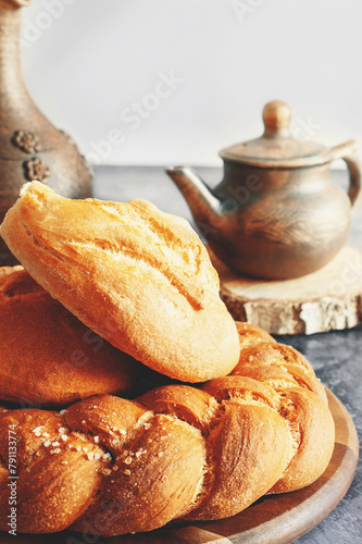 Kalach - traditional Lenten handmade bread on a rustic table illuminated by natural light from the window photo