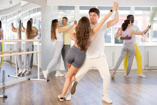 Pair of young woman and man enjoying of sensual tango dance in choreo class. Exciting hobby, active lifestyle, passion for dancing and choreography