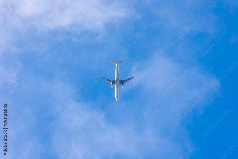Uprisen angle view of the airplane flying in the air after take off with blue sky and white clouds, Under view of aircraft above in the sky before landing, Air transportation background. Uprisen angle view of the airplane flying in the air after take off with blue sky and white clouds, Under view of aircraft above in the sky before landing, Air transportation background.
