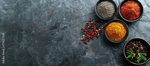 Different types of spices arranged on a stone tabletop, seen from above with space for text.