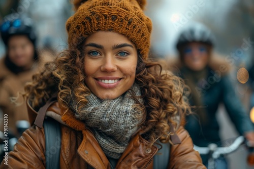 Smiling female cyclist wearing a beanie and jacket against an urban backdrop, represents active lifestyle and joy photo