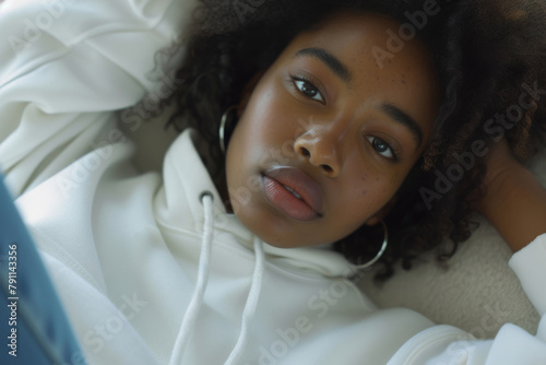 Young African American woman wearing blank basic plain white oversized hoodie. Mock up template. Closeup portrait