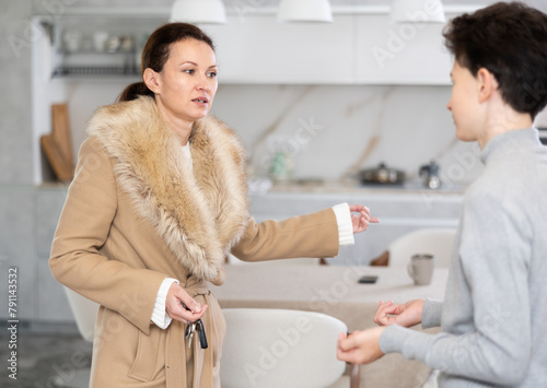 Mother leaving house and giving instructions, son staying home photo