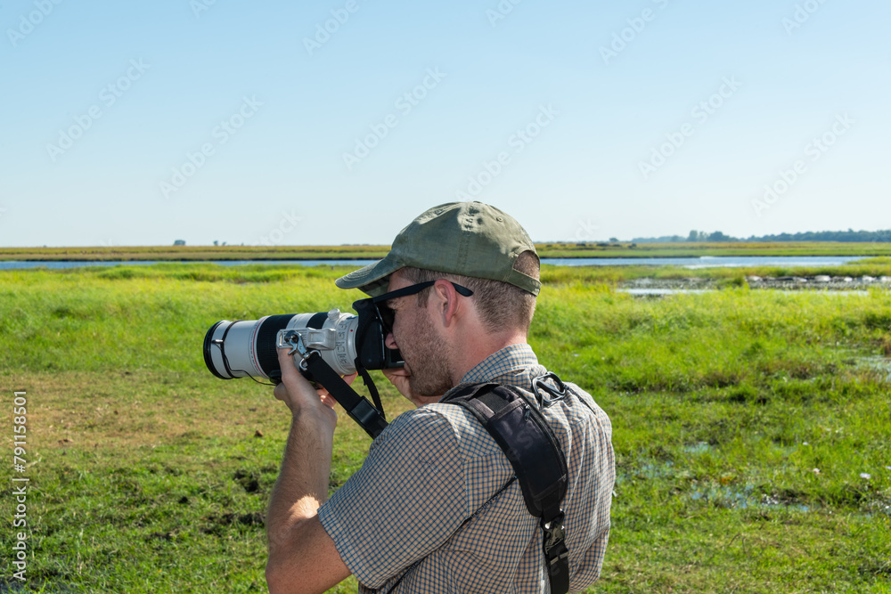 Tourist photographing wildlife while on a river cruise on the Chobe River