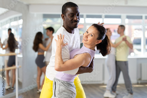 Adult man and adult woman dance ballroom dance waltz in studio