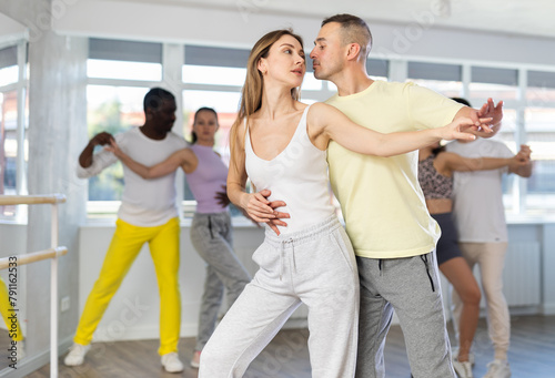 Men and women of different nationalities dancing salsa o bachata in the dance hall