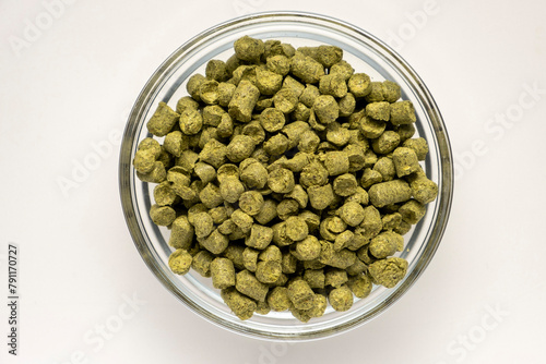 Pile of green hops pellets on white background.