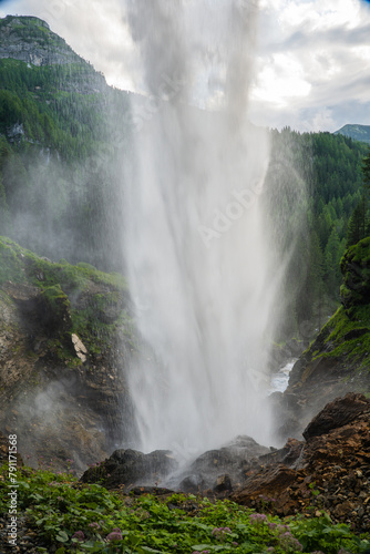waterfall cascades down the alpine mountains.stormy stream of water with drops and splashes. Downward movement of water