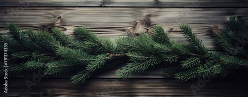 Fir tree branches arrayed across dark stained wooden boards, a natural contrast. photo