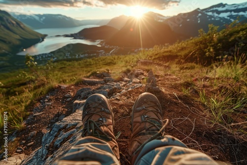 a person is sitting on top of a mountain with their feet up photo