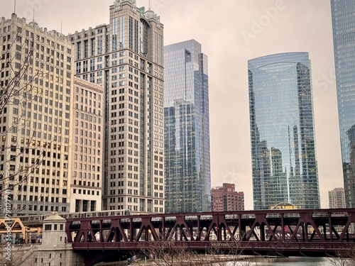 view of the chicago river with a steel bridge and the city's skyscrapers in the background under a gray winter sky 
