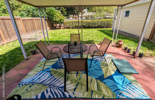 Beautiful outdoor garden terra cotta patio decorated with table, chairs, rug and potted plants