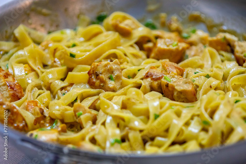 Tagliatelle in white sauce with chicken in selective focus