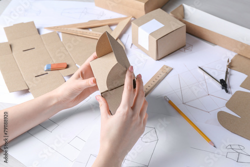 Woman creating packaging design at table, closeup photo