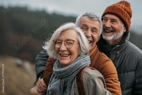 Happy senior couple hiking in the mountains. They are smiling and looking at camera.