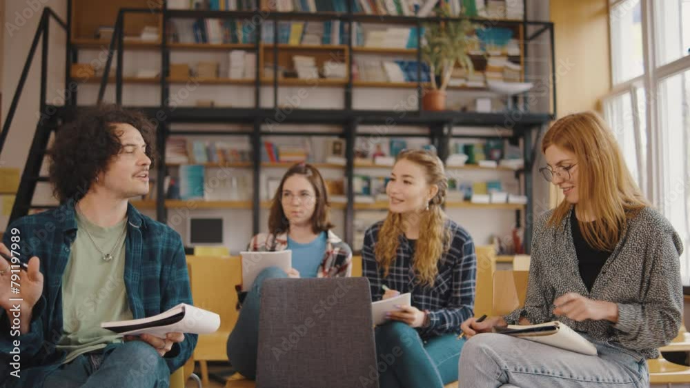 a group of students study and communicate while sitting on chairs in a library or classroom. Students in a good mood studying and reading books in the library a group of students study and communicate while sitting on chairs in a library or classroom. Students in a good mood studying and reading books in the library