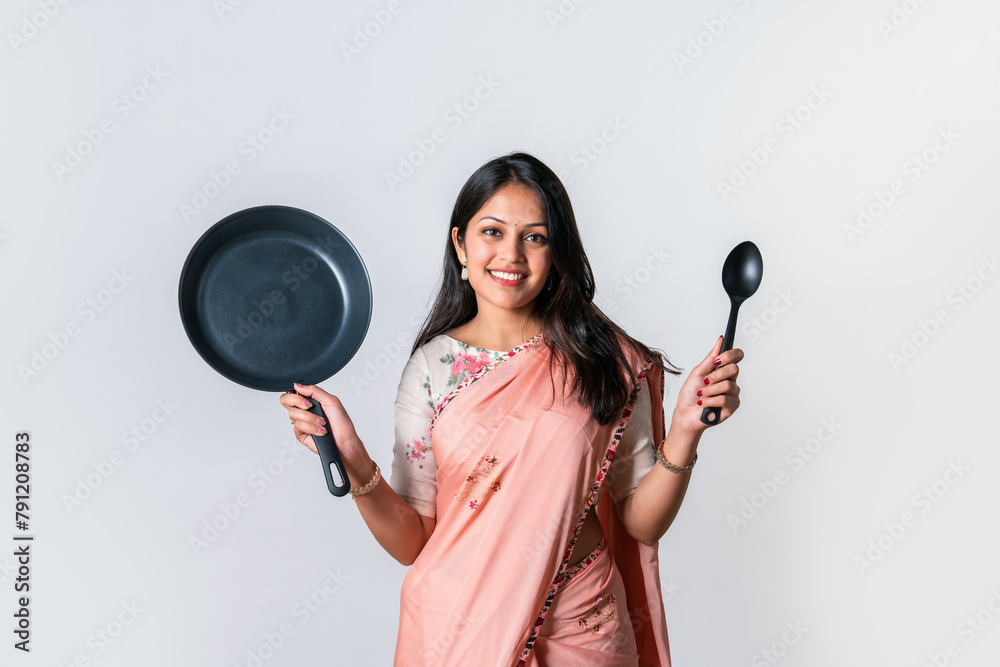 Indian asian young housewife in saree presenting kitchen utensils on white Indian asian young housewife in saree presenting kitchen utensils on white