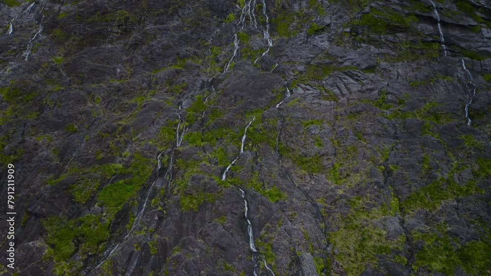 Inspiring aerial looking over rocky mountains teeming with waterfalls in Fiordland, New Zealand, South Island Inspiring aerial looking over rocky mountains teeming with waterfalls in Fiordland, New Zealand, South Island