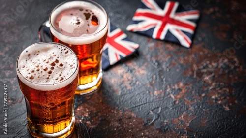 Two beer glasses with frothy tops beside British flag cushion on textured surface photo