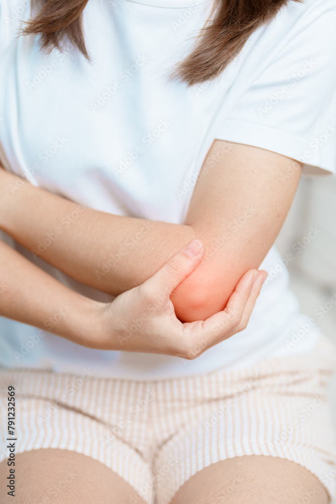 Woman having elbow ache at home, muscle pain due to lateral epicondylitis or tennis elbow. injury, Health and medical concept Woman having elbow ache at home, muscle pain due to lateral epicondylitis or tennis elbow. injury, Health and medical concept