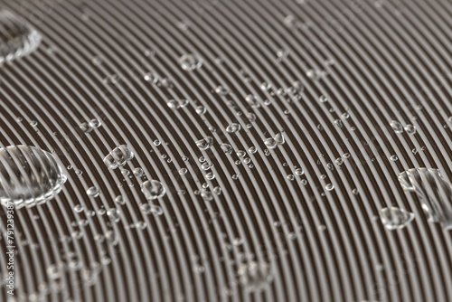 Abstract background of water drops on an aluminum surface with radial paths, thin parallel lines on metal and water drops