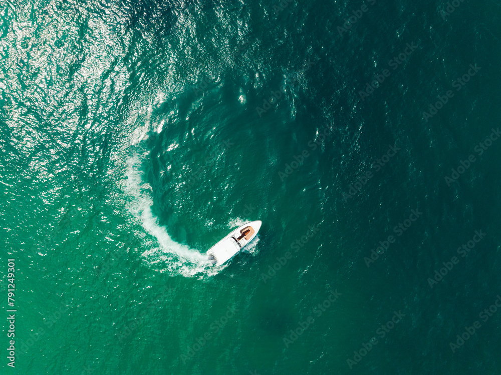 Aerial view of Speed boat in the aqua sea making a circle, Drone view.